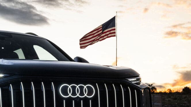 Frontale Audi nera con bandiera americana al tramonto