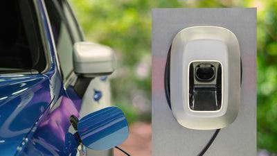 Auto elettrica blu in ricarica a colonnina