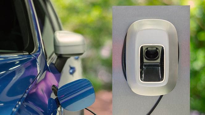 Auto elettrica blu in ricarica a colonnina