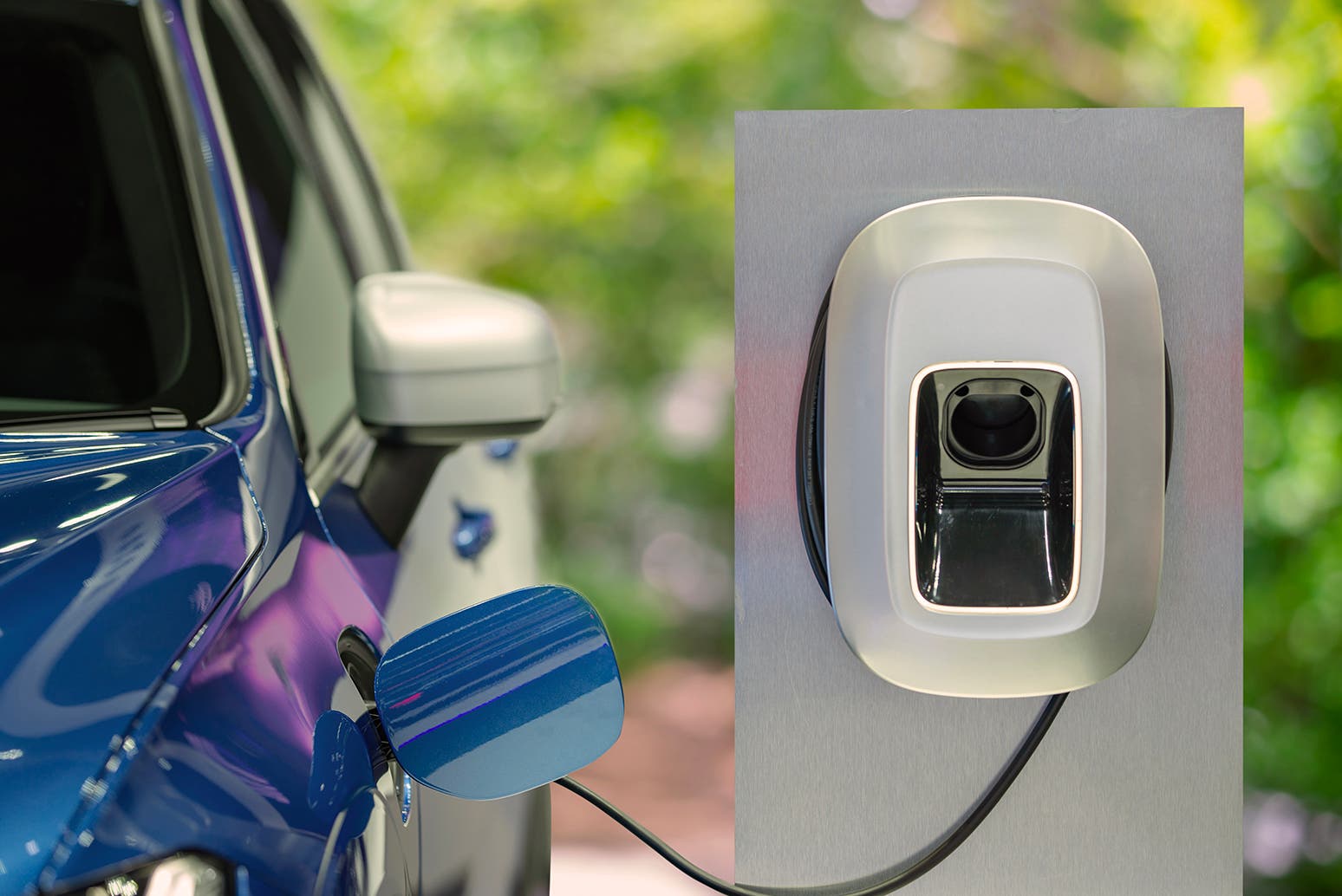 Auto elettrica blu in ricarica a colonnina