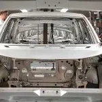 Operai assemblano scocche automobilistiche in una fabbrica