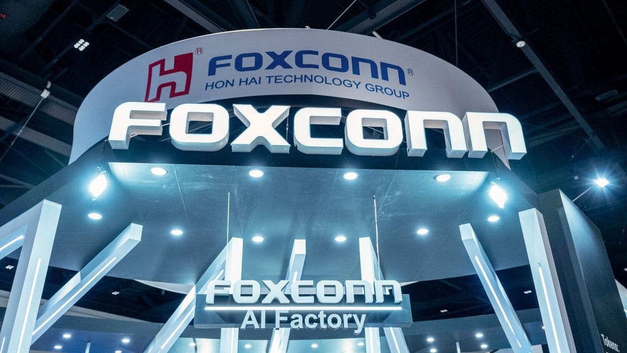 Insegna Foxconn sopra stand tecnologico illuminato