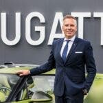 Dirigente Bugatti accanto a una supercar verde