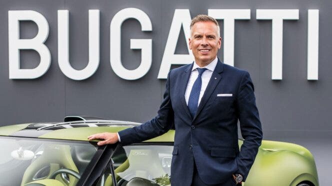 Dirigente Bugatti accanto a una supercar verde