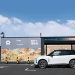 SUV elettrico bianco davanti a stazione di scambio batterie NIO