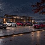 Cinque Mazda davanti a villa moderna sotto la luna