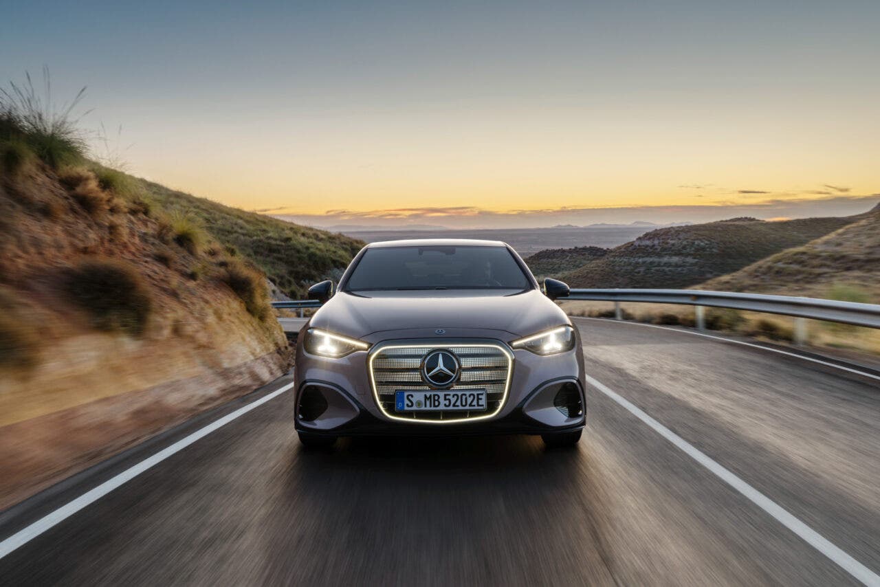 Mercedes elettrica percorre una strada collinare al tramonto