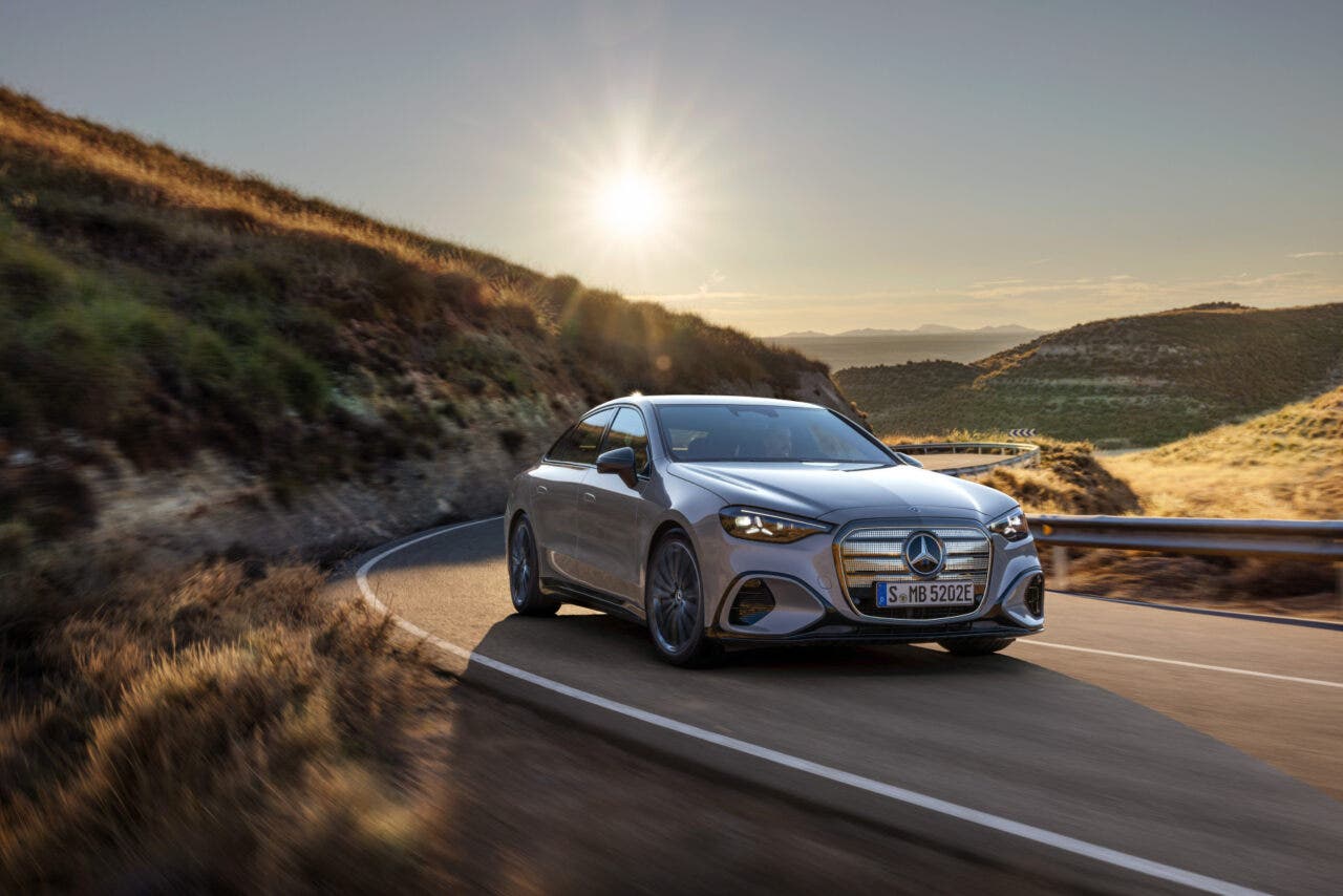 Mercedes elettrica percorre strada collinare al tramonto