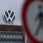 Logo Volkswagen su edificio, simbolo VW sfocato in primo piano