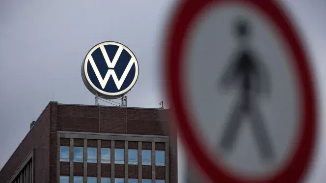 Logo Volkswagen su edificio, simbolo VW sfocato in primo piano