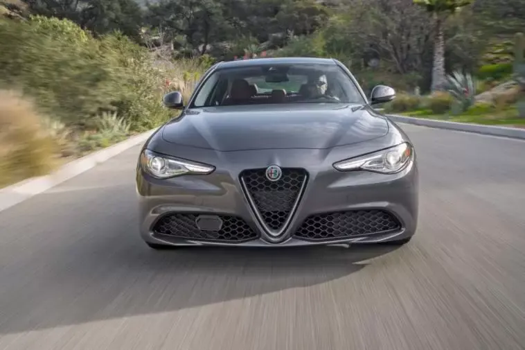 alfa romeo giuglia in movimento frontale su strada grigia