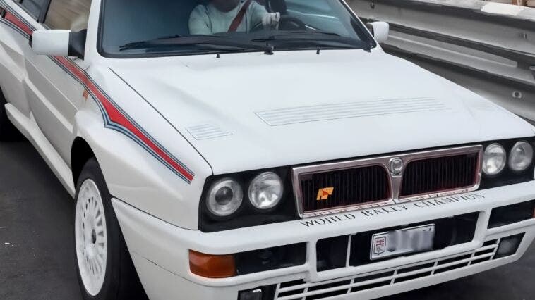 Lancia Delta Integrale bianca in strada guidata da Alonso F1