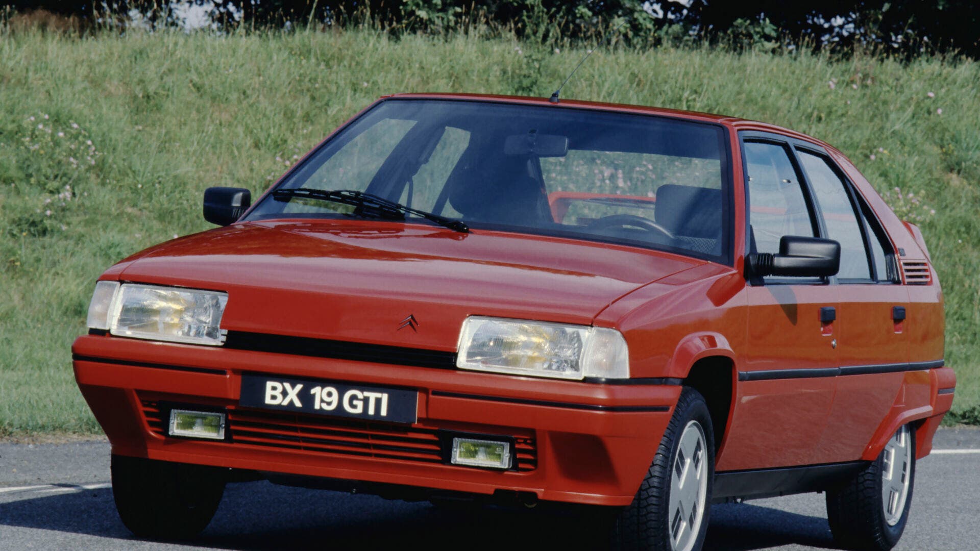 Una berlina sportiva con spoiler posteriore, fari fendinebbia e sospensioni idropneumatiche, in un'auto di fine anni '80, immagine di approfondimento